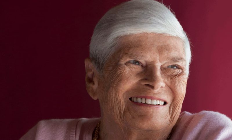 Portrait einer alten Dame mit weissen Harren die lächelt.