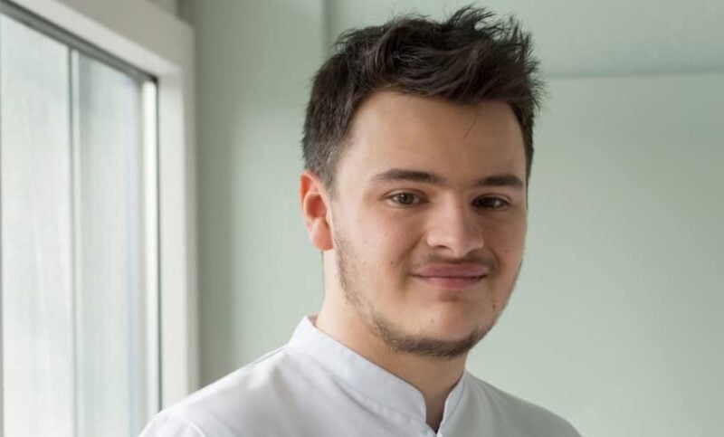 Portrait eines diplomierten Pflegefachmann in Ausbildung in Arbeitskleidung.