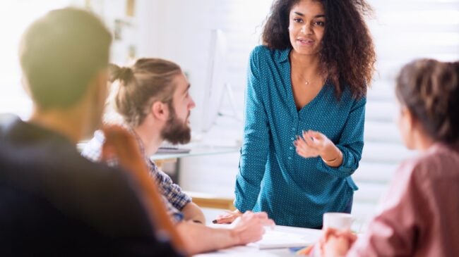 Meeting At Office. A Black Woman Talking With Her Colleagues