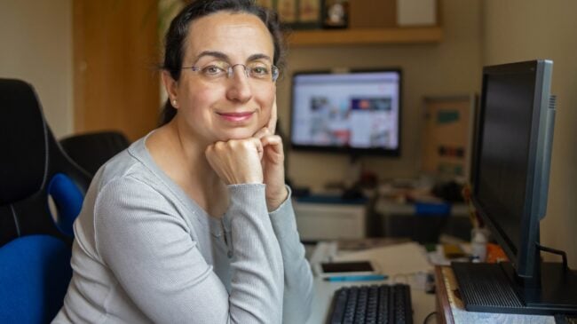 Middle Aged Pretty Woman With Glasses Looking To The Camera And Smiling